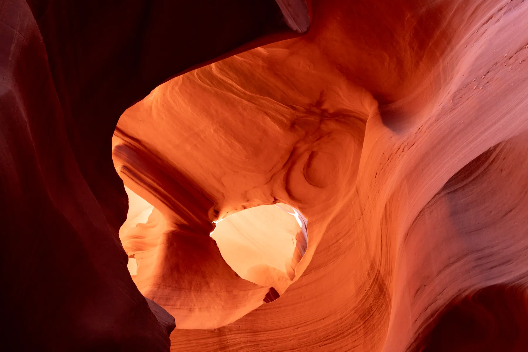 Sandstone folded around a hole to the sky.