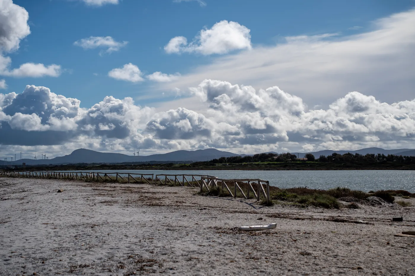 The fence along the Saline beach, wind turbines on the hills.
